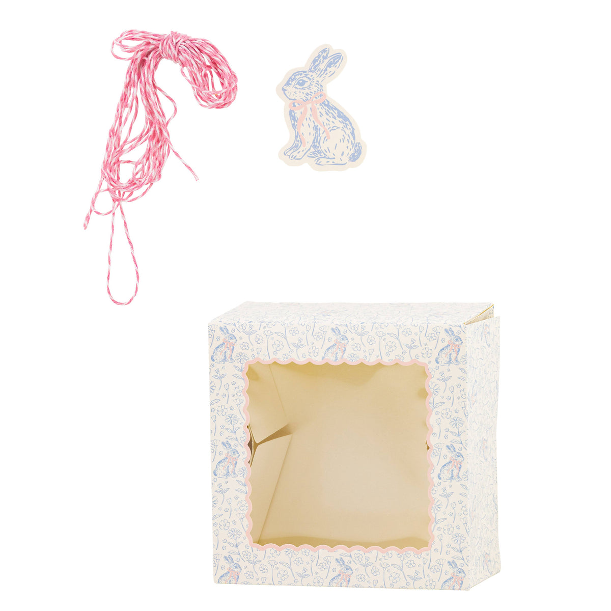 A single blue-and-white floral cookie box shown with its matching pink twine and illustrated bunny rabbit gift tag for Easter.