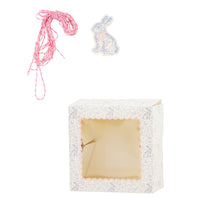 A single blue-and-white floral cookie box shown with its matching pink twine and illustrated bunny rabbit gift tag for Easter.