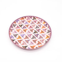 Smaller-scale overhead of the witch hat dessert plate showing the full pattern and blush scalloped edge with slight angle.