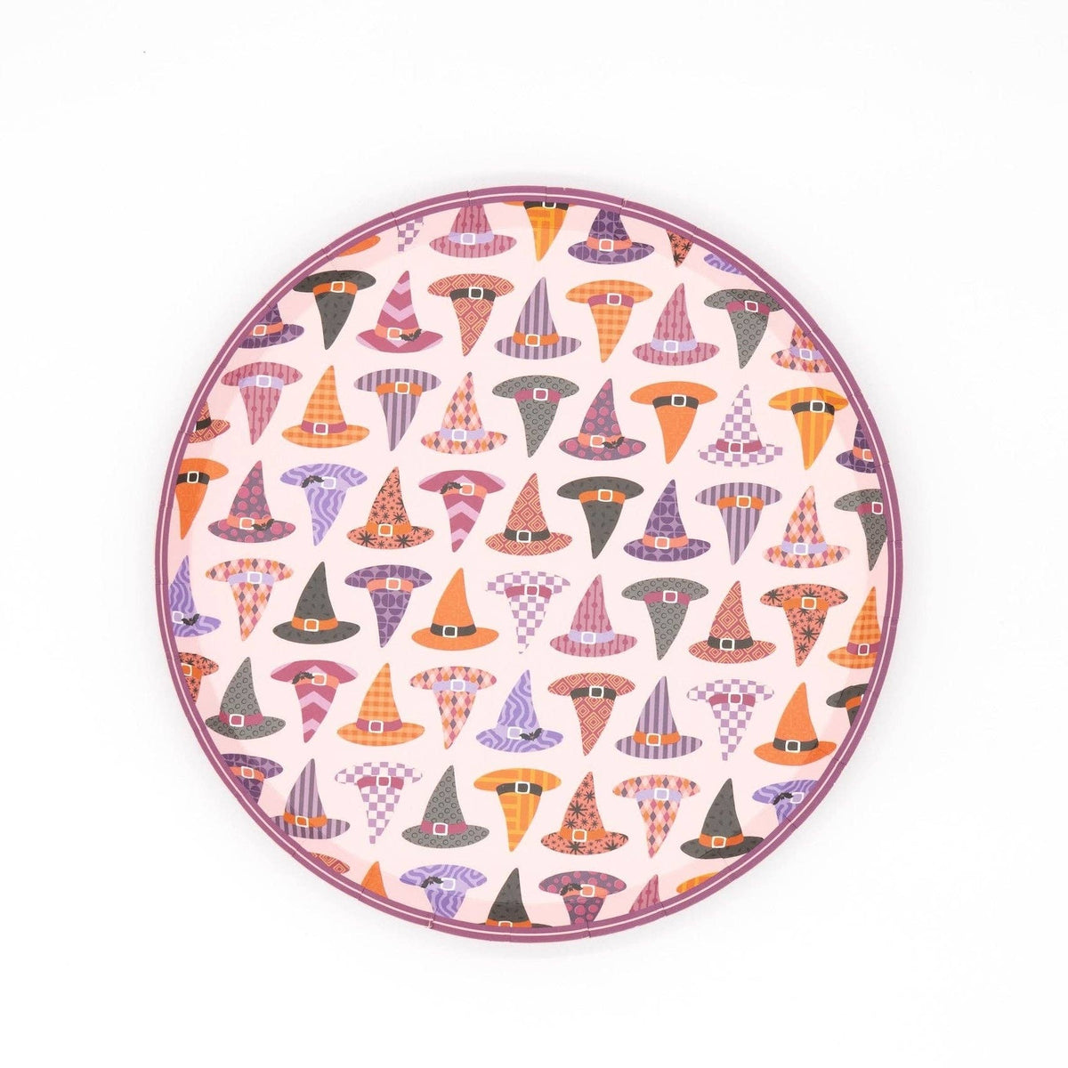 Round witch hat Halloween dessert plate covered in an all-over repeating pattern of colorful patterned witch hats in orange, lavender, blush, and black, with a blush-lavender scalloped edge, overhead flat-lay on white background.