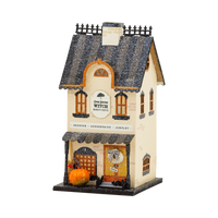 Witch Bootique light up Halloween village house in cream with a striped glitter roof, broom, pumpkin and bow wreath