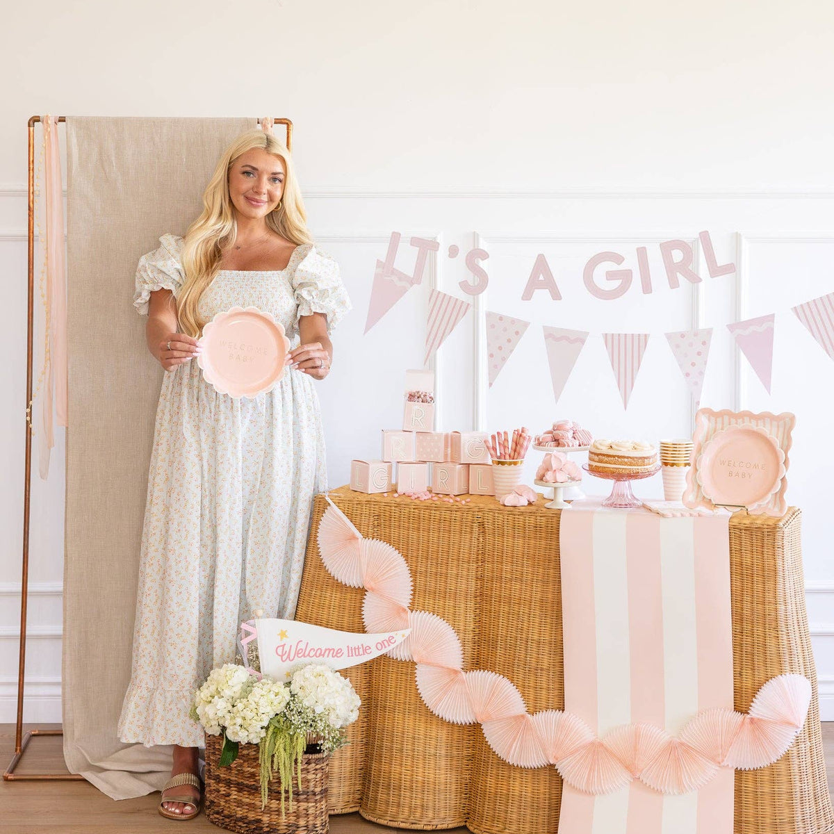 Woman holding pink scalloped paper plate in baby shower party
