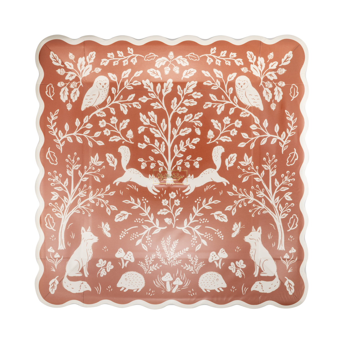 Angled view of the woodland folk-art plate showing the symmetrical deer, bird, and botanical illustration and cream wavy edge detail.
