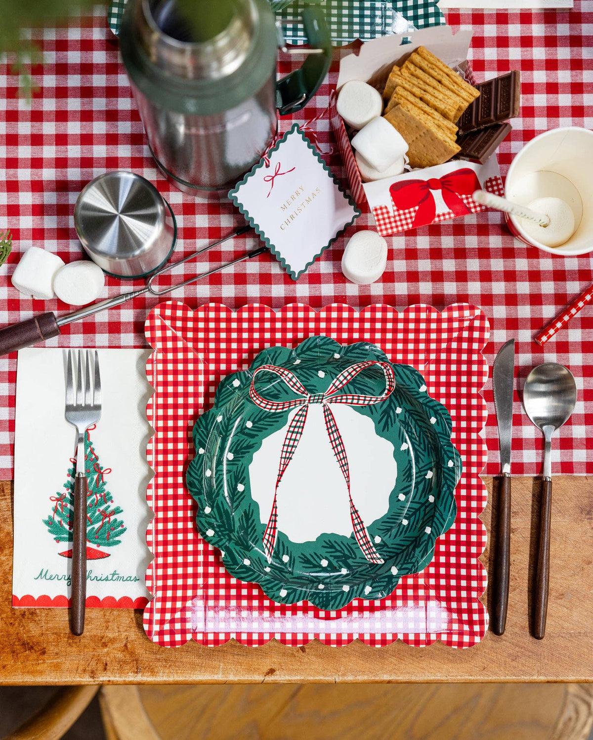 Gingham place setting with the wreath plate, a fork, and a holiday table spread.