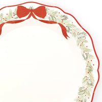 Close-up of the wreath dinner plate's red ribbon bow and berry-and-evergreen border.