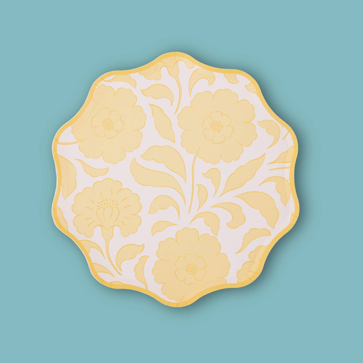 Single butter-yellow block-print floral scalloped paper plate on a teal background.