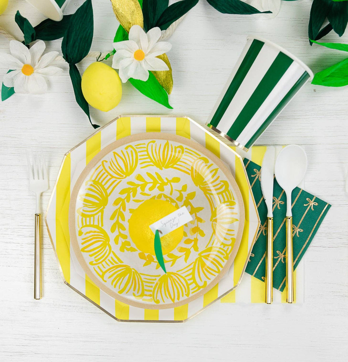 Yellow striped guest towel layered under lemon-themed party plates.